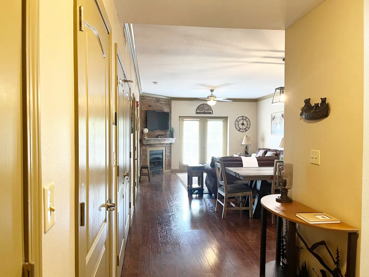 The image displays a warm, open living area featuring a dining table and sofa with a fireplace in the background. This central space is ideal for family gatherings, intimate meals, or game nights, evoking the comfort and versatility highlighted in the section during cooler months.